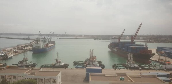 A harbor with multiple ships docked, cranes, and a calm water body. - Hôtel Plaza Arzew (Arzew)