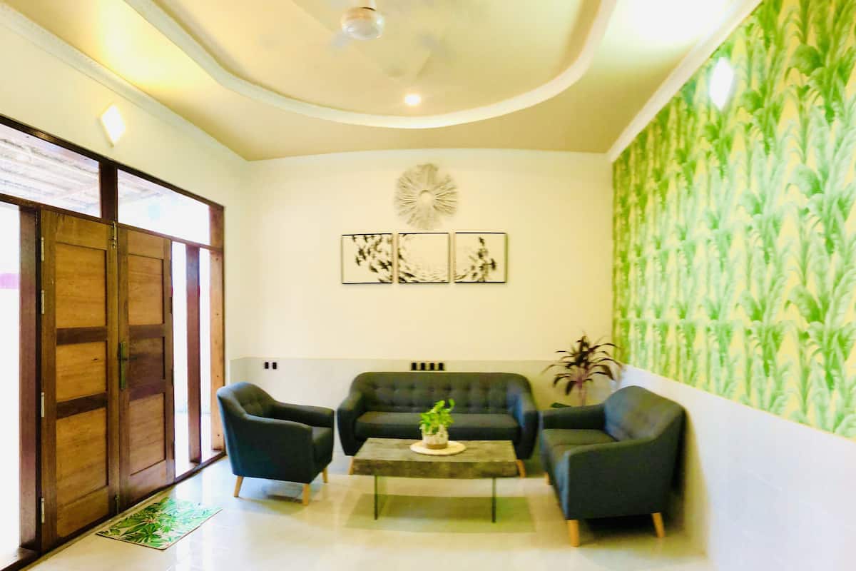 A modern living room with a sofa set, a coffee table, and a decorative wall.