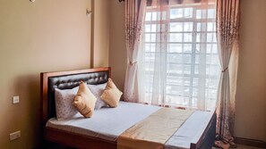 Enjoy a restful night's sleep in this stylish bedroom with a tufted headboard and city views.