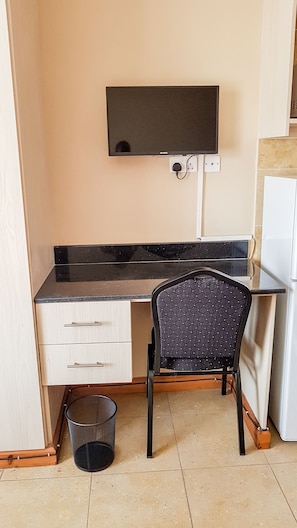 Enjoy a convenient kitchenette with a sink, chair, and TV.