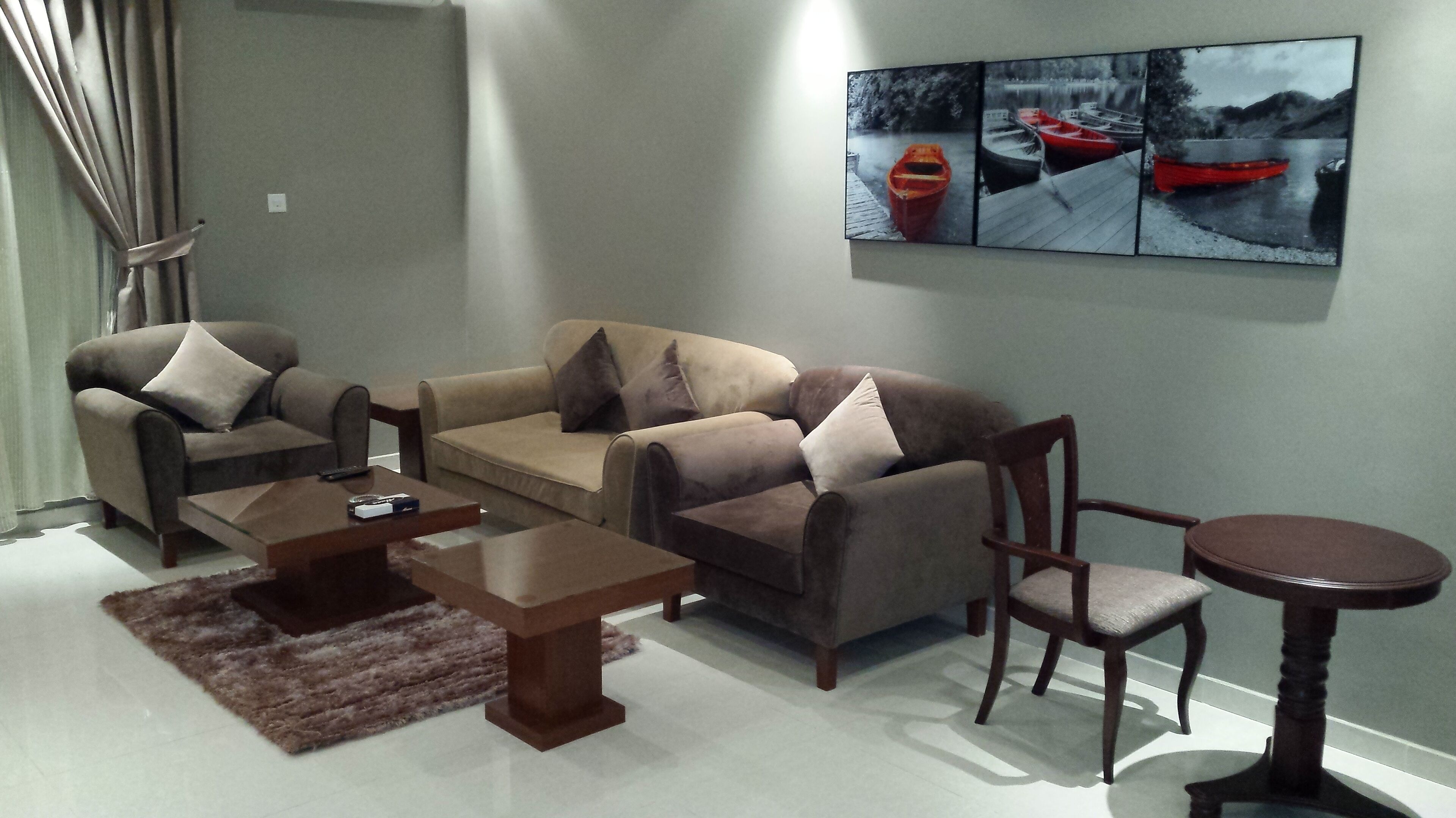 A living room with a sofa set, a coffee table, a side table, and a small round table.