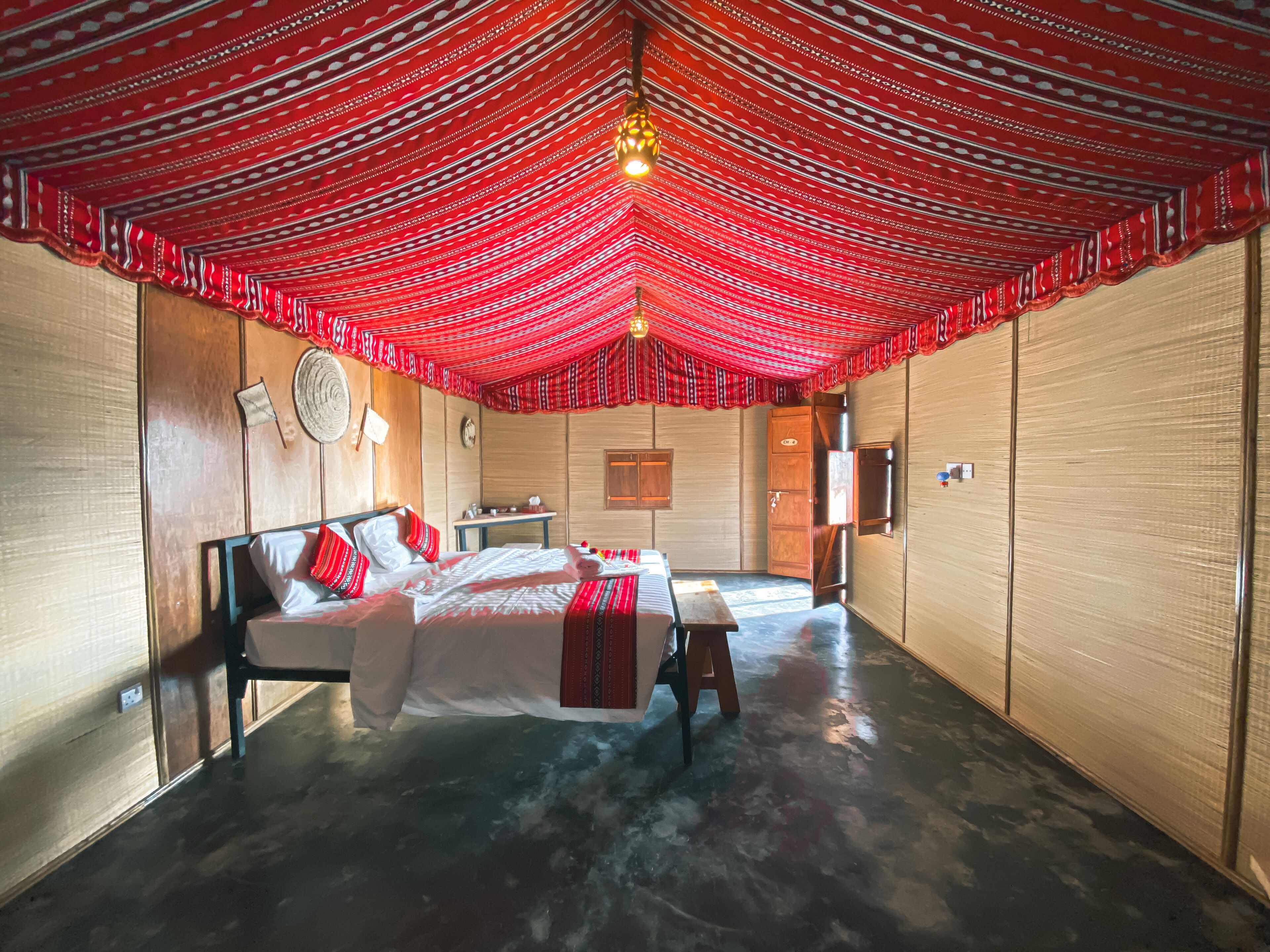A room with a bed, a desk, and a wardrobe.