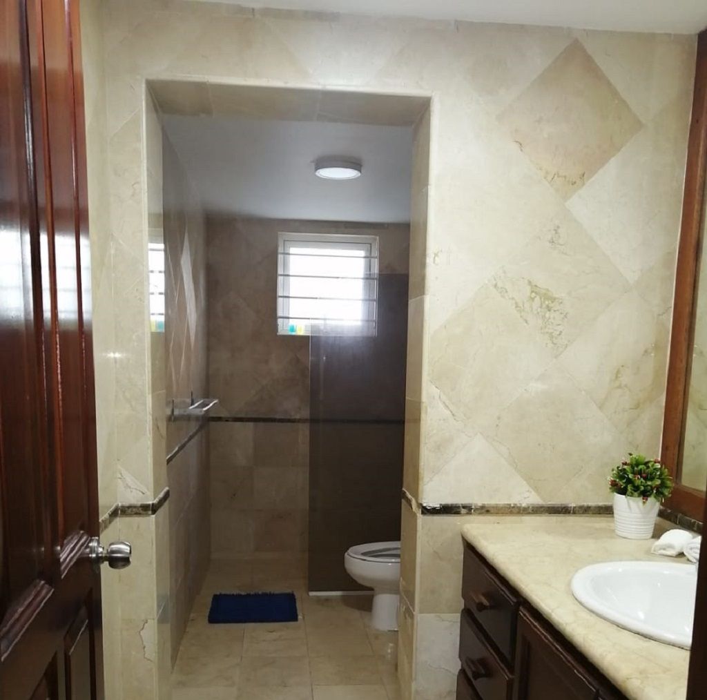 A bathroom with a shower, toilet, and sink.
