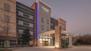 Un hôtel Fairfield by Marriott Inn & Suites au design moderne, avec une entrée imposante, un passage couvert et un pilier en pierre.