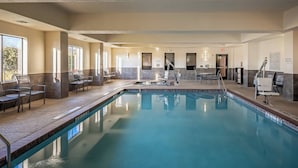 Une piscine dotée de chaises longues et d’une terrasse ensoleillée.