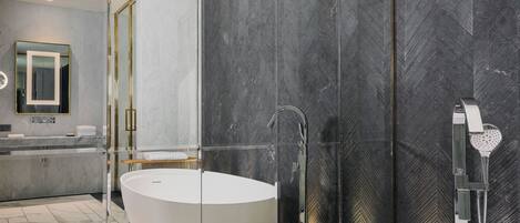 Un baño moderno con una bañera independiente, un lavabo separado y una zona de ducha con paredes de vidrio.