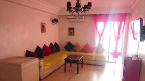 A living room with a sofa, a coffee table, and a television. - Beautiful apartment in Residence with Swimming pool 4624 (Marrakech)