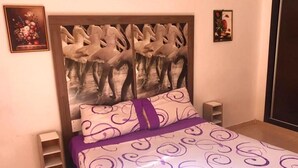 A bedroom with a large bed, a headboard with a ballet dancer design, a small bedside table, and a wall-mounted shelf. - Beautiful apartment in Residence with Swimming pool 4624 (Marrakech)