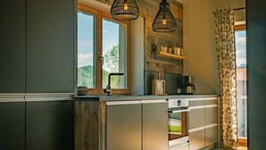 Une cuisine moderne avec des éléments en bois, une fenêtre et des luminaires suspendus.
