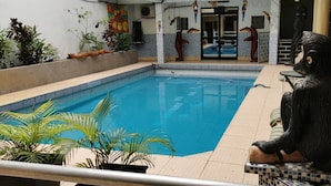 An indoor swimming pool with a tiled border, surrounded by potted plants and a decorative sculpture. - Gran hotel Jungla (Iquitos)