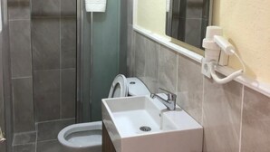 Ein Badezimmer mit Dusche, Toilette und Waschbecken.