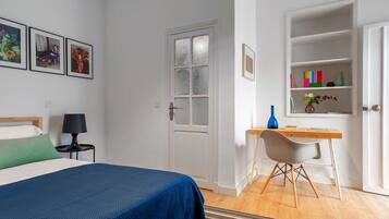 A bedroom with a bed, a desk, a chair, and a bookshelf.