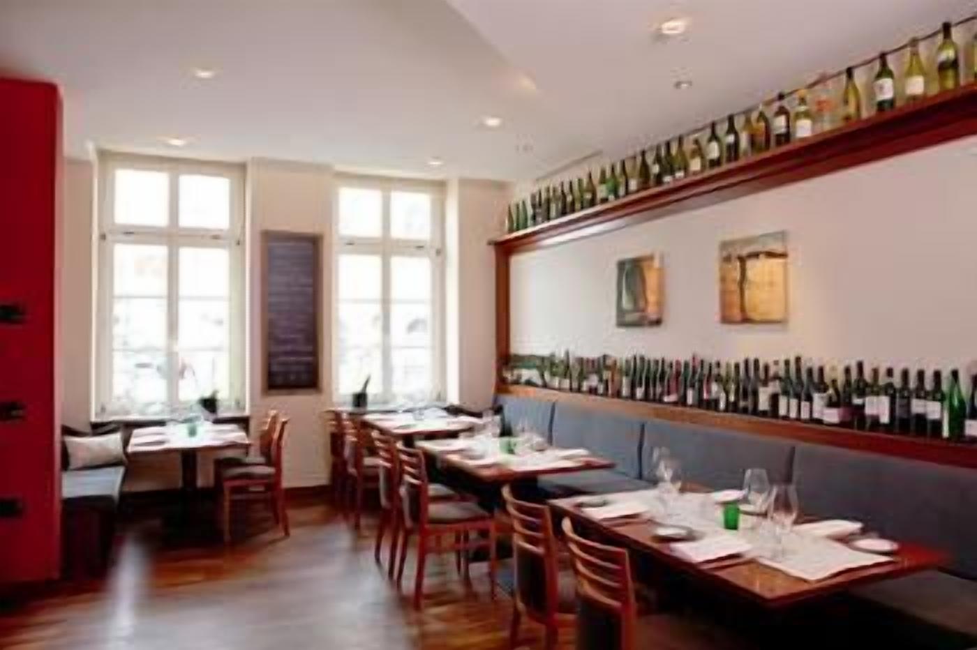 Ein Restaurant mit langen Tischen, Stühlen und einer Weinstraße.