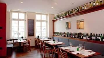 Ein Restaurant mit langen Tischen, Stühlen und einer Weinstraße.