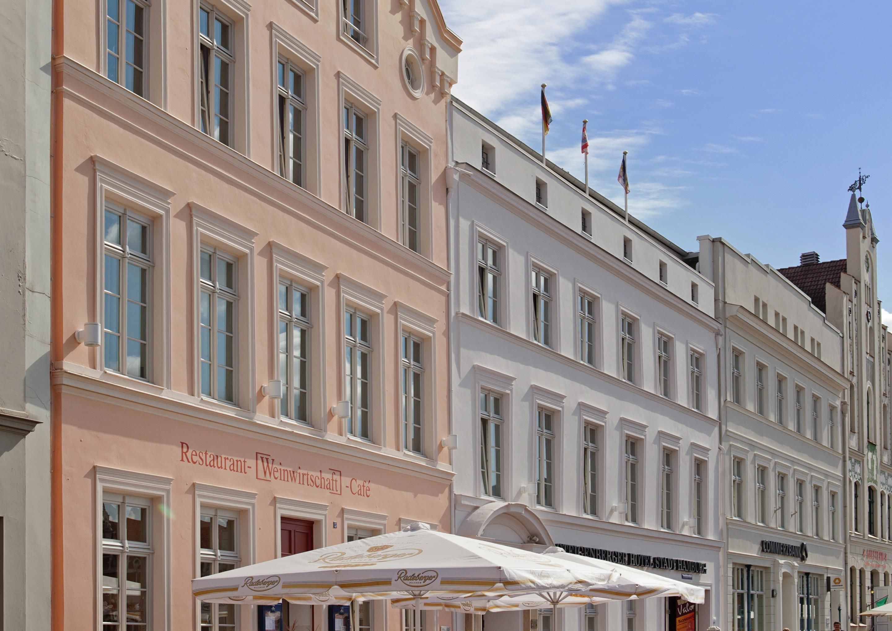 A building with a sign reading 'Restaurant Weinwirtschaft - Café' and a row of windows.