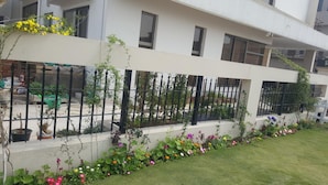 A modern building with a white facade, multiple windows, and a black metal fence. - Valley View Villa (Rawalpindi)
