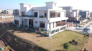 A modern two-story residential building with a flat roof, large windows, and a spacious front yard. - Valley View Villa (Rawalpindi)