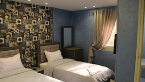 A hotel room with two beds, a large mirror, and a patterned wall. - Sunset Hotel Cairo - Hostel (Cairo)