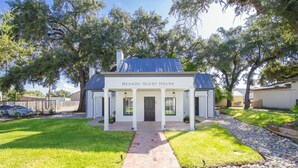 A two-story building with a dark roof and white exterior, labeled "Benson Guest House." - Benson Guest House (Uvalde)