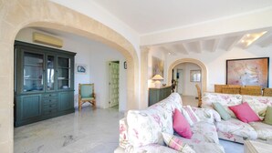 A spacious living area with a floral sofa, a green cabinet, and a marble floor. - CAN RAMIS -  Seafront house with panoramic views. (Cielo de Bonaire)