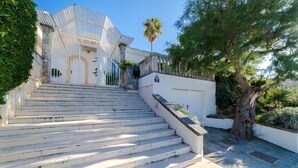A set of stone steps leading to a white building with a covered entrance. - CAN RAMIS -  Seafront house with panoramic views. (Cielo de Bonaire)