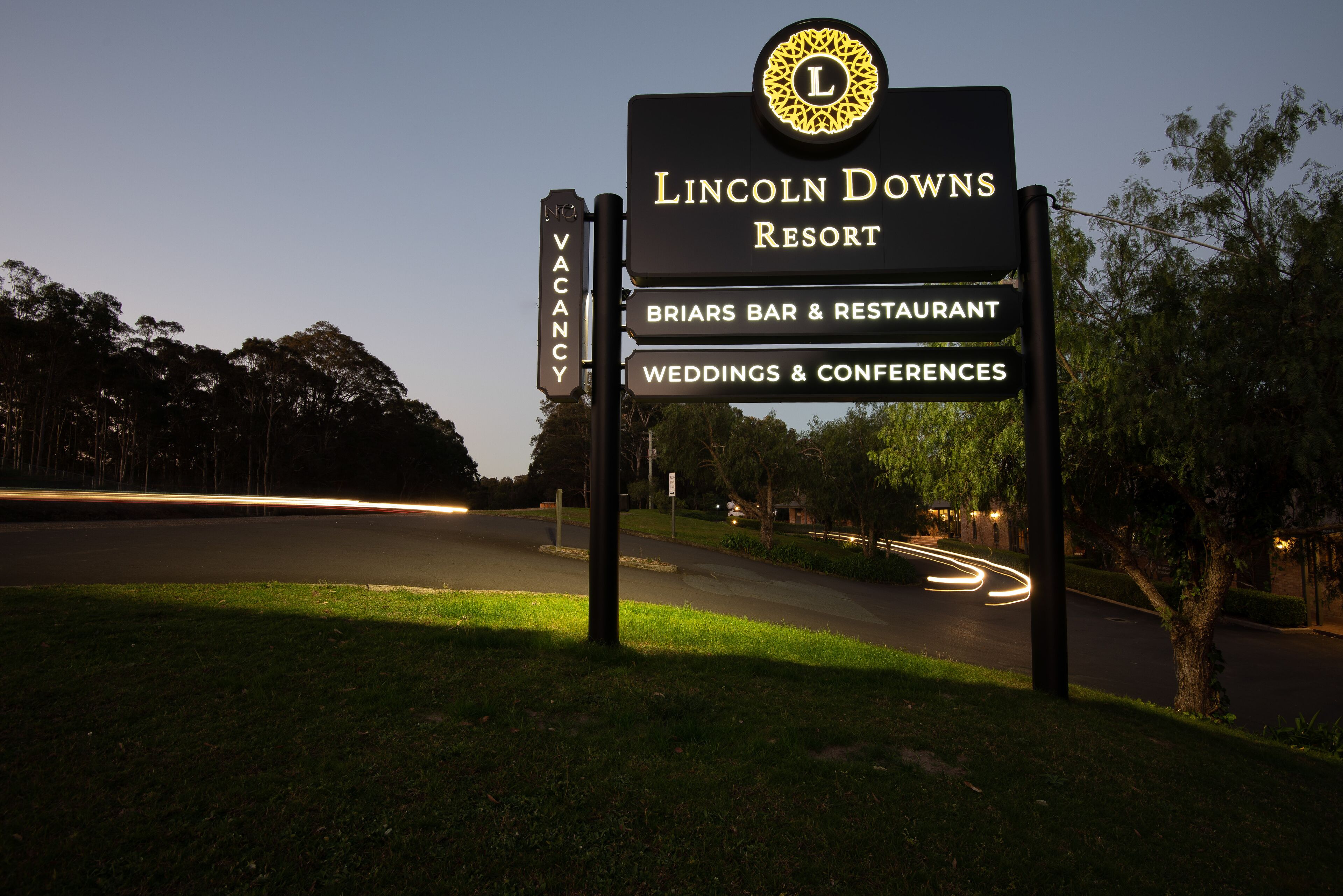 A sign for Lincoln Downs Resort with amenities including a bar, restaurant, and services for weddings and conferences.