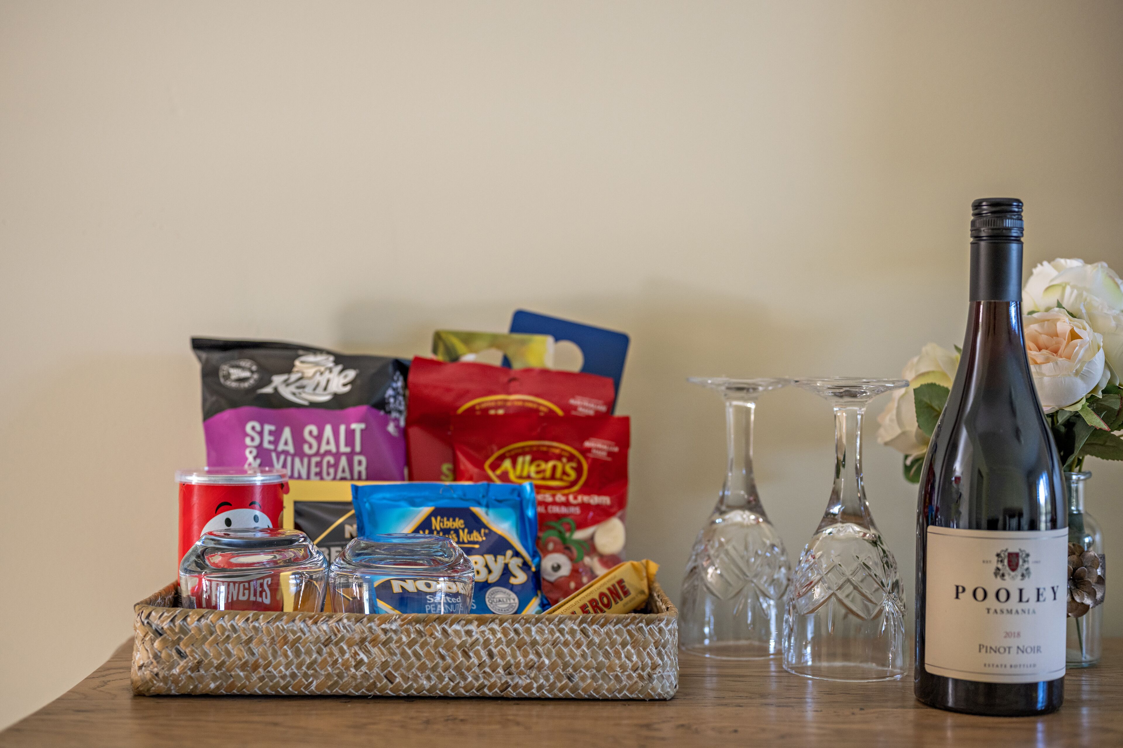 Une table avec une bouteille de vin, des verres et divers aliments.