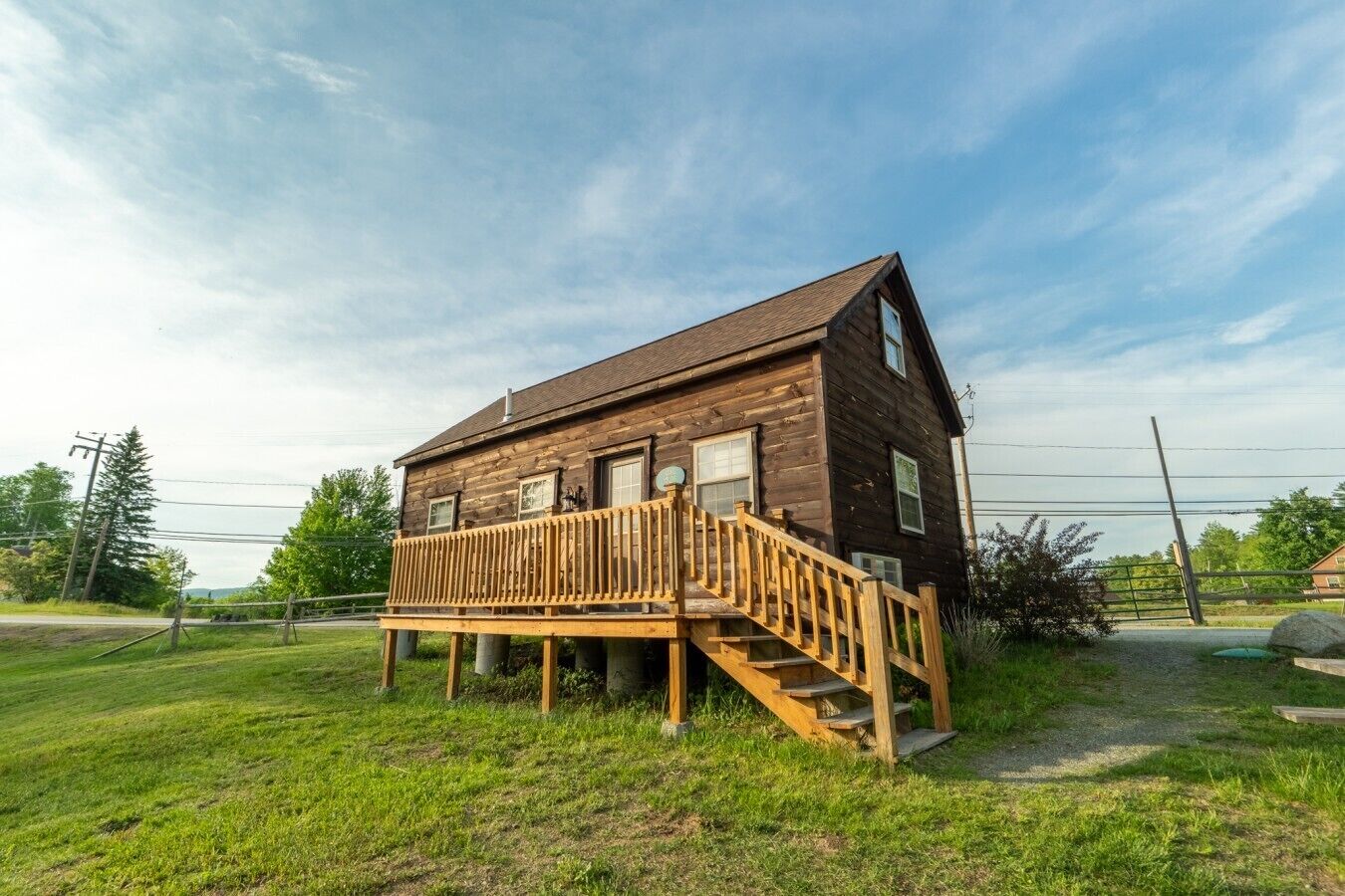 A wooden cabin with a deck and stairs leading to the entrance.