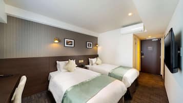 A hotel room with two beds, a desk, a chair, a flat-screen TV, and a door leading to another room.