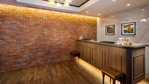A reception area with a brick wall, wooden counter, and a bench. - Best Western Hotel Fino Shin-Yokohama (Yokohama)
