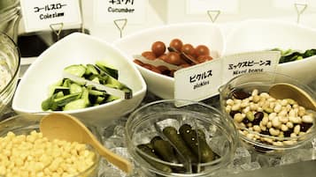 A selection of pickled vegetables and beans in bowls, with labels in a foreign language.