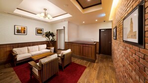 A modern hotel lobby with a wooden reception desk, a sofa, and a coffee table. - Best Western Hotel Fino Shin-Yokohama (Yokohama)