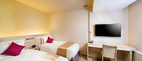 A hotel room with two beds, a desk, a chair, and a TV.
