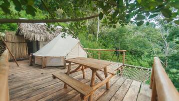Relax on the deck surrounded by lush greenery, perfect for dining or socializing.