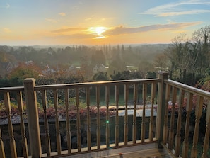 A wooden deck with a railing overlooking a landscape with trees and houses. - 1 bedroom accommodation in Wherwell (Wherwell)