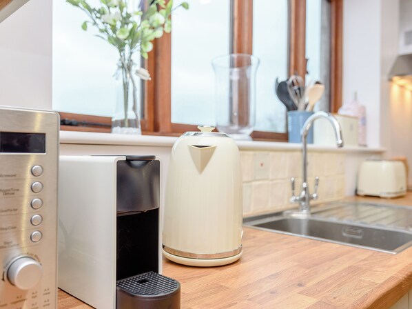 A kitchen with a coffee maker, a microwave, and a toaster on the counter.