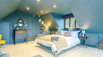 Une chambre à coucher avec un lit, une commode, une table de chevet, une lampe et une fenêtre.