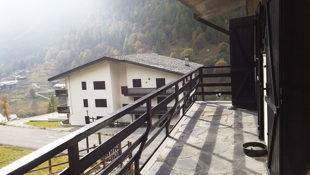 A building with a balcony, a stone floor, and a view of a valley. - Singlin Home - Skiing, trekking, holiday home. (Valtournenche)