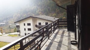 A building with a balcony, a stone floor, and a view of a valley. - Singlin Home - Skiing, trekking, holiday home. (Valtournenche)