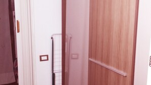 A hallway with a wooden wardrobe, a white door, and a tiled floor. - Singlin Home - Skiing, trekking, holiday home. (Valtournenche)