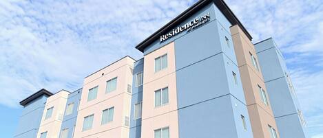 A multi-story hotel with a modern design, featuring a prominent "Residence Inn by Marriott" sign at the top.