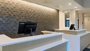 A modern reception area with a Lenovo computer station, a refrigerator, and a mirror. - Residence Inn by Marriott Richmond West/Midlothian (Richmond)