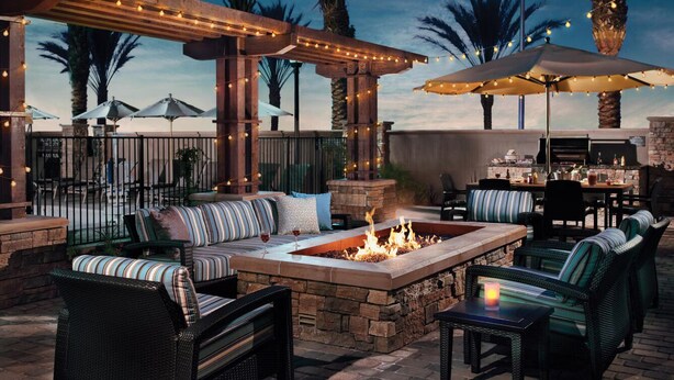 An outdoor patio with a fire pit, seating, and umbrellas. - Residence Inn by Marriott Richmond West/Midlothian (Richmond)