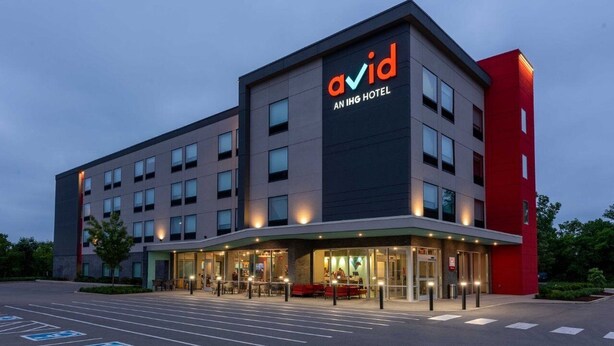 Un hôtel moderne, reconnaissable à son grand panneau « avid », doté de plusieurs étages et d’un parking comprenant des places réservées aux personnes handicapées.