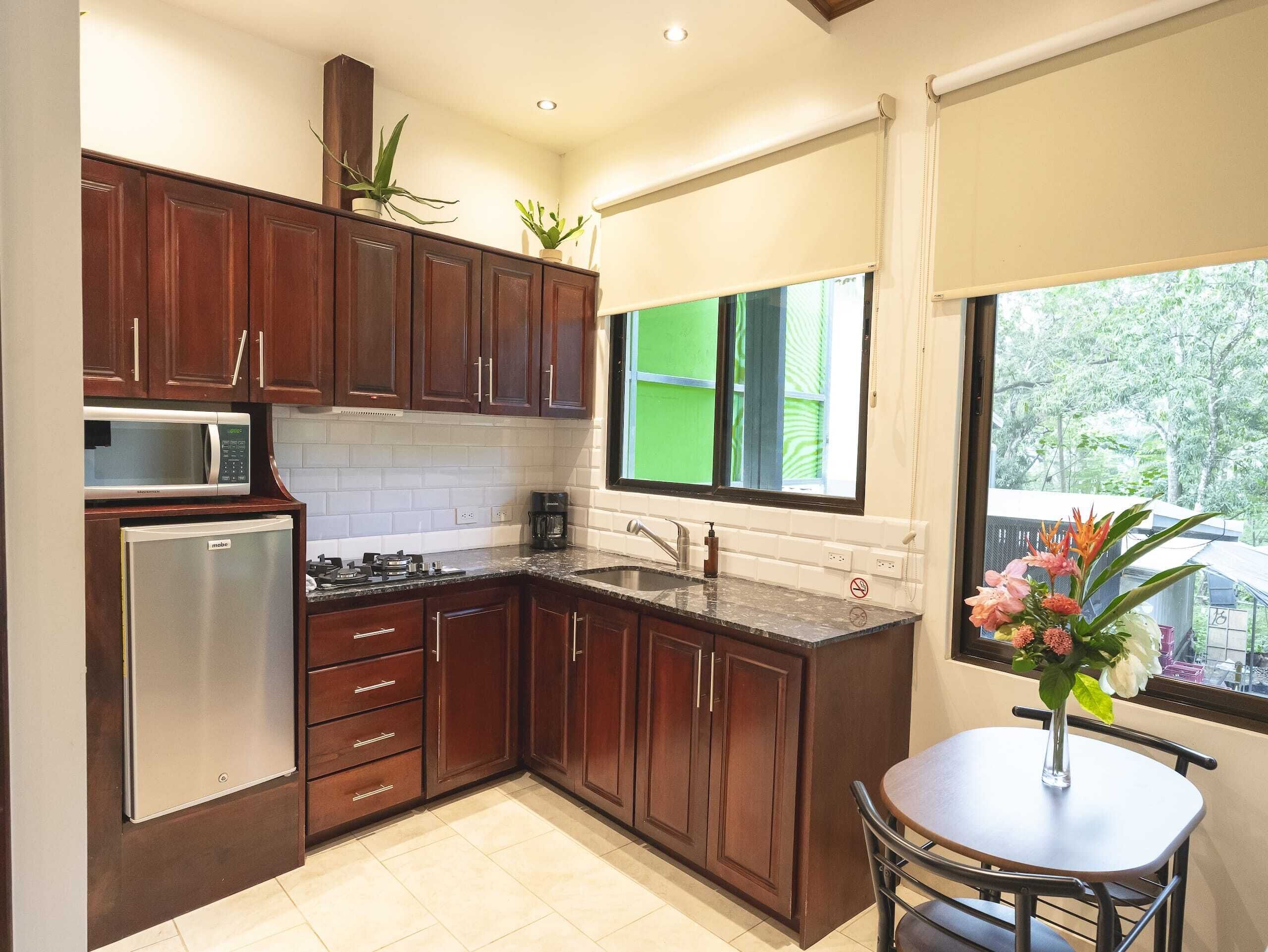 Una cocina moderna con armarios de madera, un microondas integrado y un refrigerador.