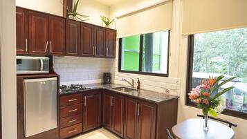 Una cocina moderna con armarios de madera, un microondas integrado y un refrigerador.