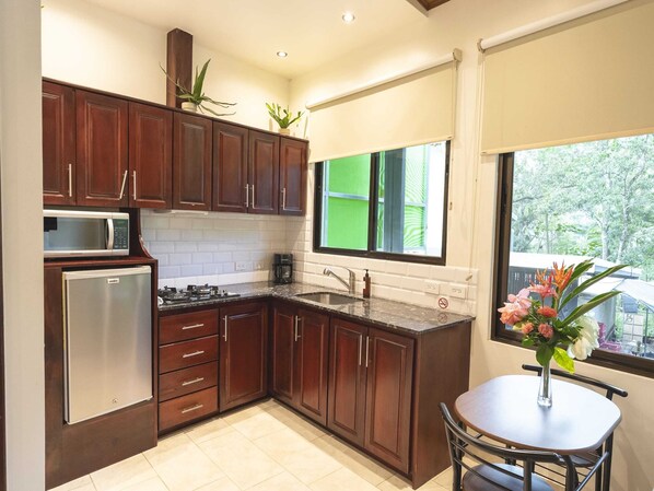 Una cocina moderna con armarios de madera, un microondas integrado y un refrigerador.