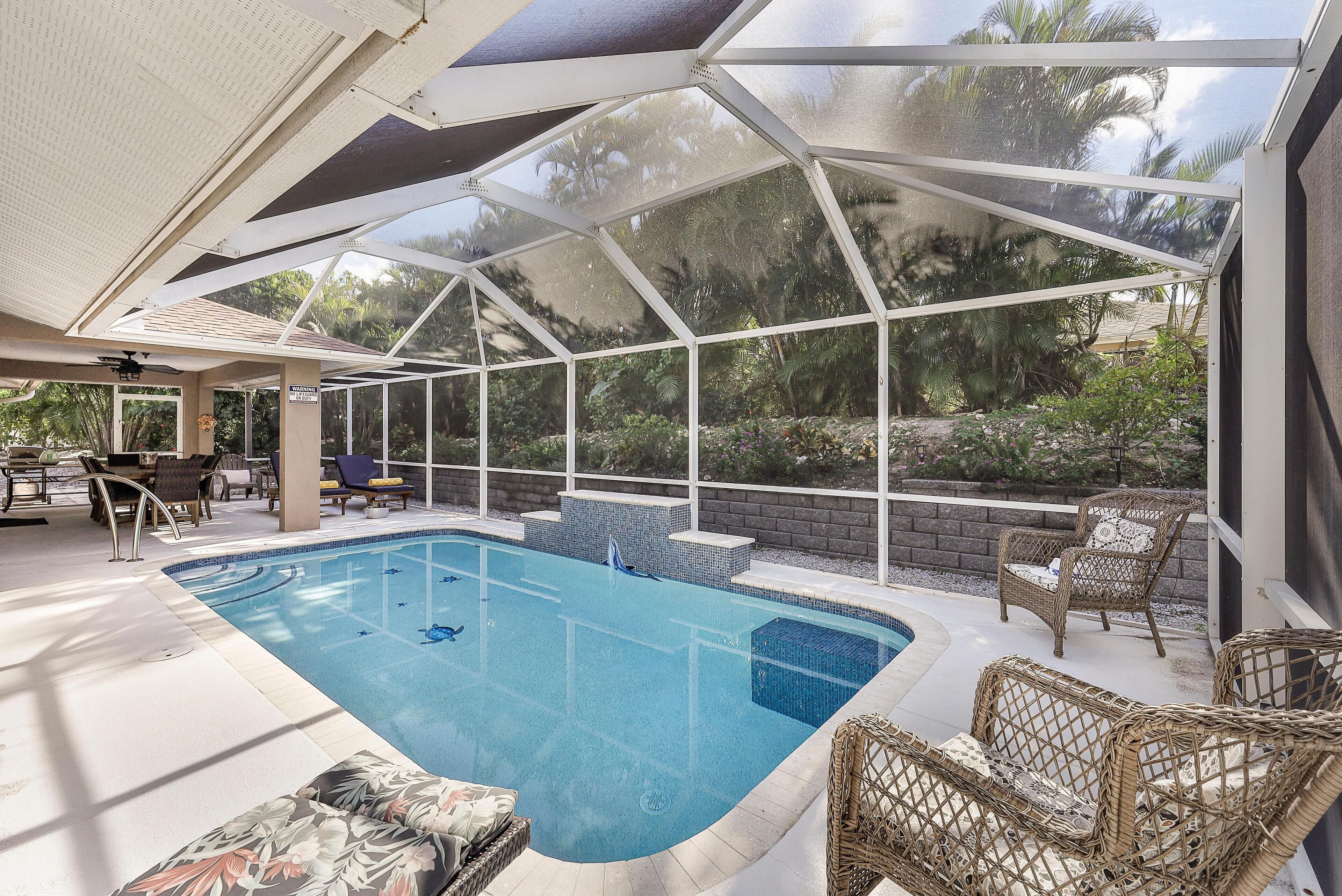 Ein überdachter Pool mit Liegestühlen und einer Terrassenfläche.