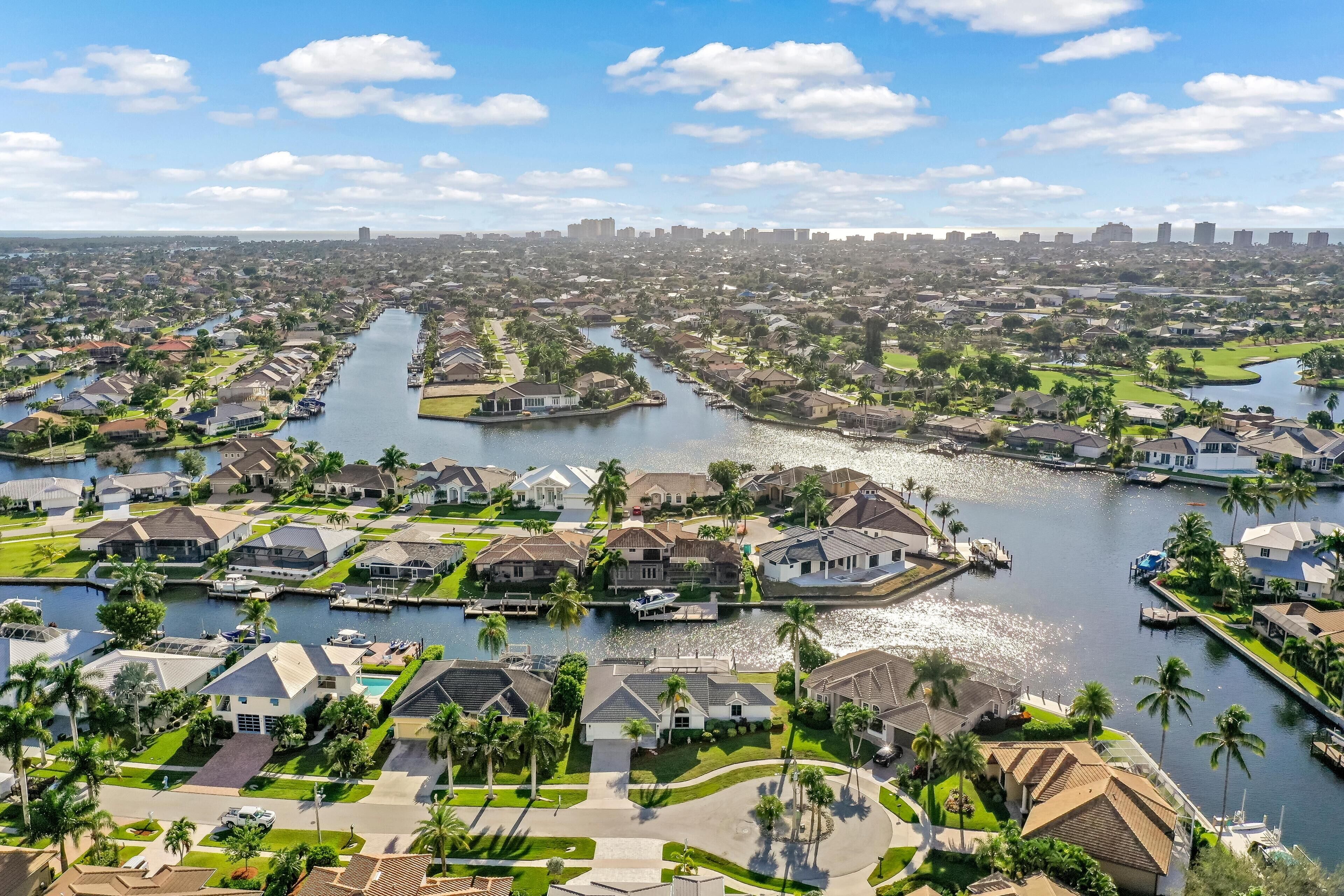 Un quartier résidentiel avec des maisons, un canal et, au loin, la silhouette de la ville.