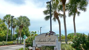 A sign for Mackle Park with an eagle emblem, surrounded by palm trees and landscaped gardens. - Southwinds B-2 (Marco Island)